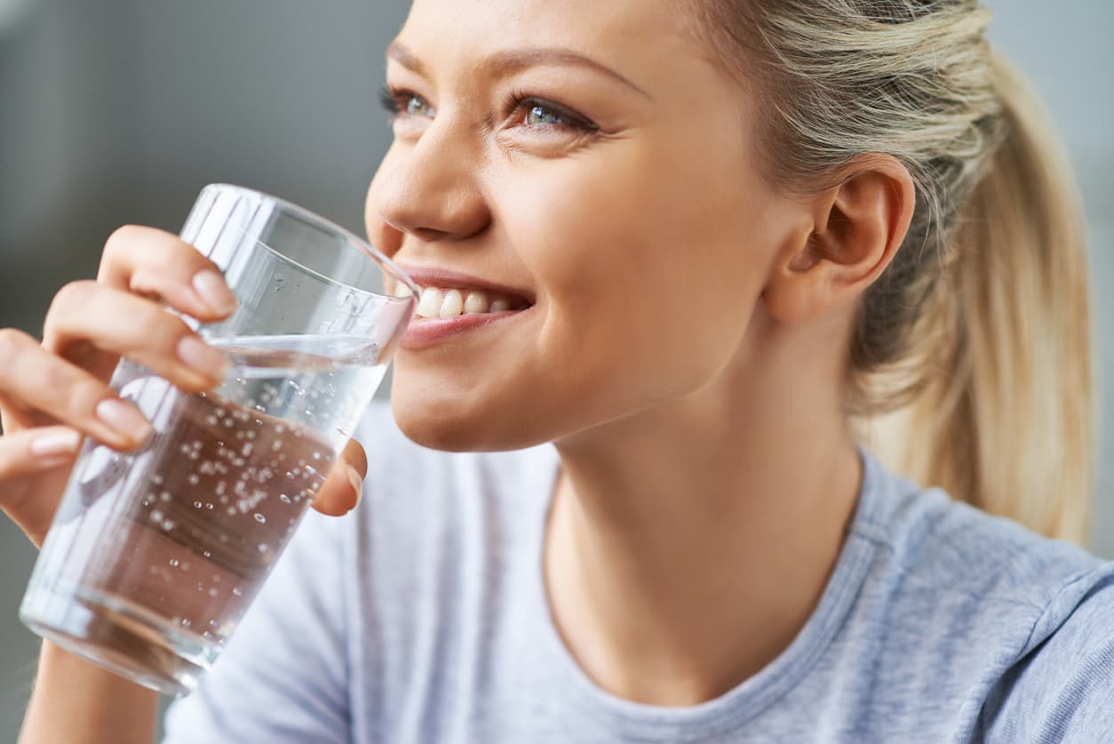 Beautiful young woman drinking water
