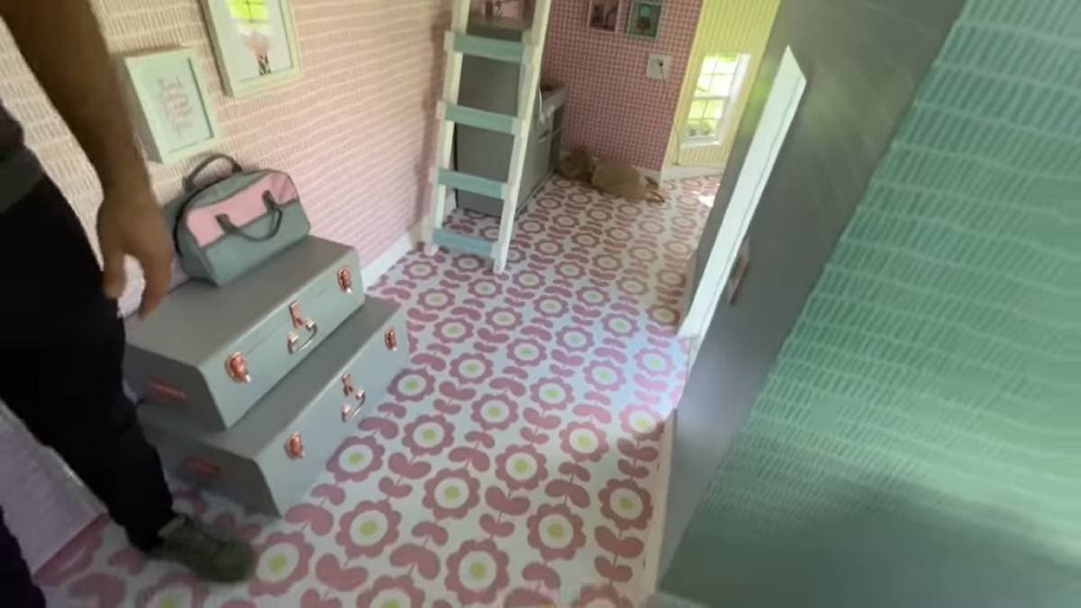 En la parte de abajo de las escaleras, está ubicada la cocina, en la que se observan los muebles en color gris oscuro junto a grandes ventanales.